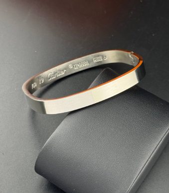 بنگل صلب مردانه رنگ مشکی با طراحی تخت و سطح صیقلی مدل کارتیه روی پایه