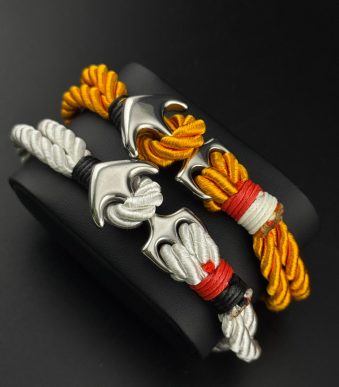 جزئیات قفل لنگر استیل نقرهای و نوارهای قرمز و مشکی روی دستبند نخی اسپرت