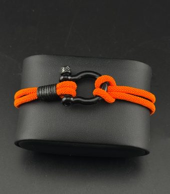 نمای نزدیک قفل استیل نقرهای پیچی روی دستبند نخی نارنجی